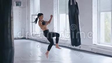 跆拳道职业运动员女子在健身房踢拳袋。 体育跆拳道女子在健身房训练。